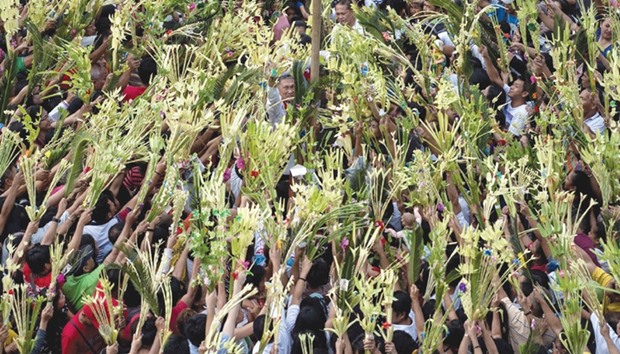 A layman of the Roman Catholic Church blesses palms during Palm Sunday celebrations in Bulacan, north of Manila yesterday.