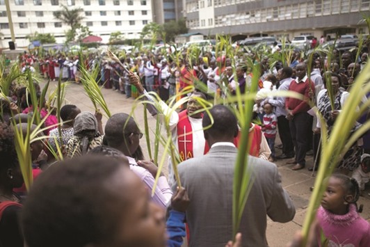 A member of the Catholic Christian clergy blesses worshippers with holy water during a Palm Sunday ceremony in Nairobi yesterday.