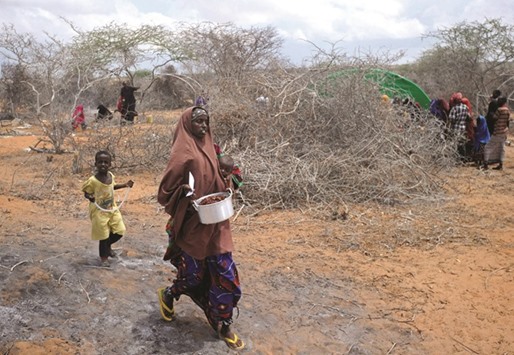 Newly displaced Somali women and children walk to a food distribution point at the Kaxda district, outskirts of Mogadishu. Somalia, a Horn of Africa country of 12mn people, is facing its third famine in 25 years of civil war and anarchy.