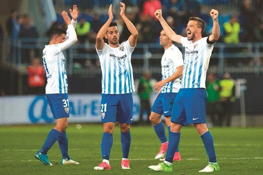 Malagau2019s players celebrate after their win over Barcelona at La Rosaleda stadium in Malaga, Spain, on Saturday night. (AFP)