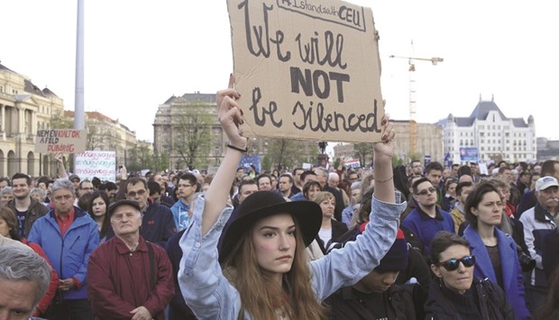 A woman holds up a placard as she protests against the bill that would undermine the Central European University, a liberal graduate school of social sciences founded by US financier George Soros.