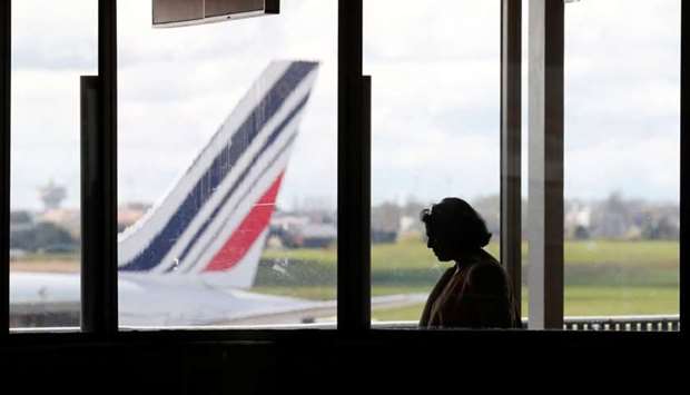 A passenger walks as Air France planes are parked on the tarmac at Orly Airport near Paris as Air France pilots, cabin and ground crews unions call for a strike over salaries, France.
