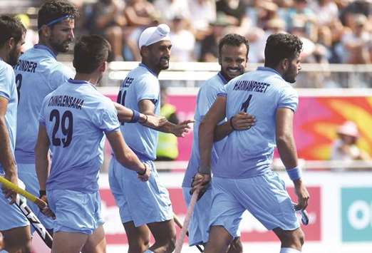Harmanpreet Singh (right) of India is congratulated by his teammates after scoring his first goal during the menu2019s field hockey match against Malaysia at the 2018 Gold Coast Commonwealth Games on the Gold Coast yesterday. (AFP)