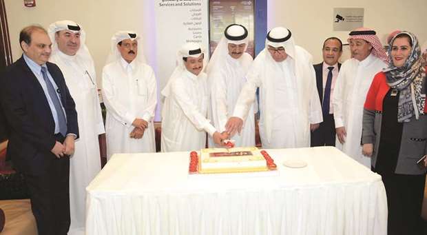 Sheikh Abdullah leads the cake cutting ceremony with Commercial Bank vice-chairman Hussain Ibrahim Alfardan and VIP customer Ali al-Sada during the opening of the new Al Ruwais branch yesterday. Looking on are managing director Omar Hussain Ibrahim Alfardan, Group CEO Joseph Abraham, EGM Consumer Banking Amit Sah, and other dignitaries. PICTURES: Mohamedali A K