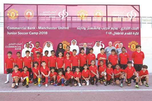 Commercial Bank officials with some of the children participating in the soccer school provided by the bank.