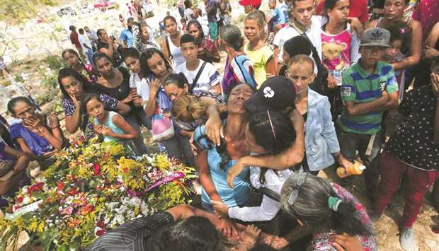 Relatives grieve during the funeral of some of the victims of the prison fire, in Valencia, northern Carabobo state, Venezuela.