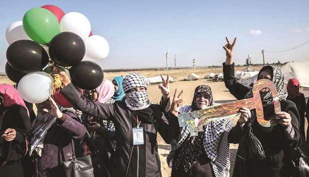 Palestinian women hold balloons at the site where tents are pitched in support of refugees returning to land they fled or were expelled from during the 1948 war surrounding Israelu2019s creation, near the border, east of Rafah, in the southern Gaza Strip, yesterday.