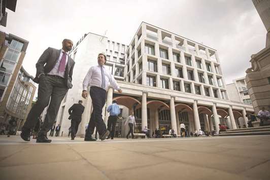 Pedestrians walk past the London Stock Exchange offices. China is aiming to start a stock trading tie-up between Shanghai and London this year, according to a top official, creating a system that would give investors in the worldu2019s most populous country direct access to shares listed in the UK.