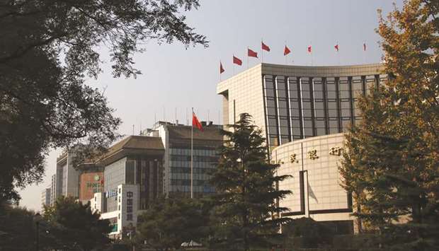 The Peopleu2019s Bank of China headquarters (right) in Beijing. China will raise foreign ownership limits to 51% in securities, fund management, futures and life insurance companies u2018over the next few monthsu2019, the PBoC said in a statement on its website yesterday.