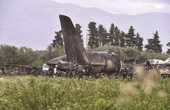 Rescuers are seen around the wreckage of an Algerian army plane which crashed near the Boufarik airbase from where the plane had taken off, yesterday.