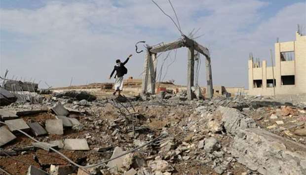 A man is seen at the site of an air strike that destroyed the Community College in Saada, Yemen on Thursday.