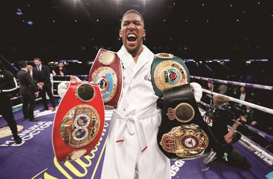 Anthony Joshua celebrates with the belts after winning the fight.  (Reuters)