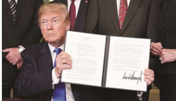 US President Donald Trump signs trade sanctions against China on March 22, 2018, in the Diplomatic Reception Room of the White House in Washington, DC.