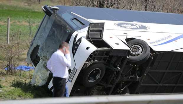 A man walks beside a crashed bus on a highway near capital Sofia, Bulgaria.