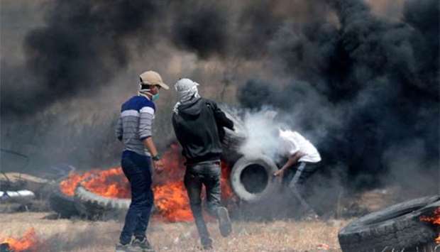 Palestinian protesters burn tyres during clashes with Israeli forces east of Khan Yunis in the southern Gaza city, on Friday.