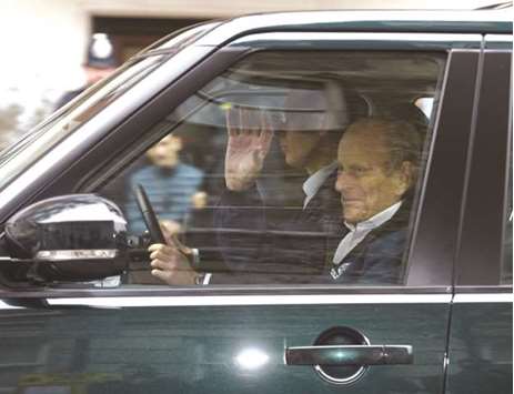 Prince Philip waves as he is driven away from King Edward VIIu2019s Hospital where he recently underwent hip replacement surgery, in central London, yesterday.