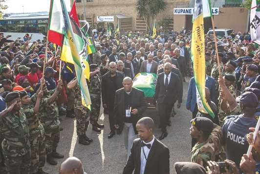 Pall bearers carry the casket of Winnie Madikizela-Mandela covered with an ANC flag as remains of the the anti-apartheid icon are returned to her home in Soweto, Johannesburg, yesterday.