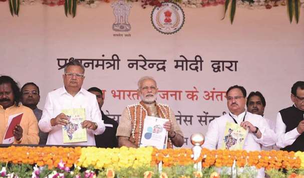 Prime Minister Narendra Modi unveils a book Health Atals after inaugurating a health and wellness centre to mark the launch of Ayushman Bharat Yojana, in Bijapur in Chattisgarh yesterday. Also seen are Chhattisgarh Chief Minister Raman Singh, and federal Health Minister J P Nadda.