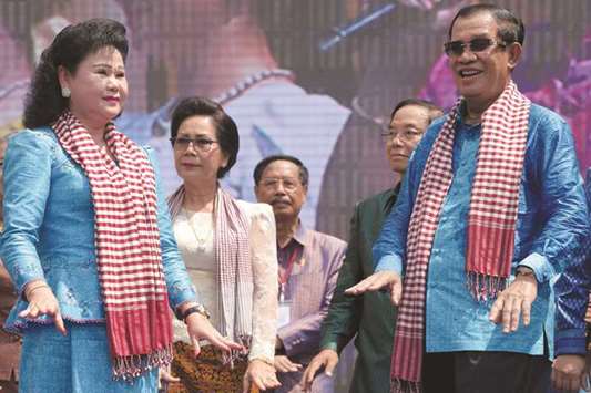 Cambodiau2019s Prime Minister Hun Sen, right,  and his wife Bun Rany dance on stage during an opening ceremony for the Khmer New Year at Bayon temple at the Angkor complex in Siem Reap province.