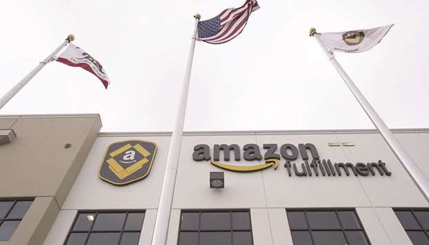Amazon.com signage is displayed on the facade of the companyu2019s fulfilment centre in Tracy, California (file). President Donald Trump issued a surprise order on Thursday for his administration to study the US Postal Service after his campaign manager  complained to him that taxpayers were subsidising Amazon.com at the expense of small businesses.