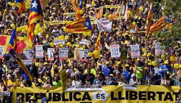 People march behind a banner reading ,Republic is freedom, and wave Catalan pro-independence 'estelada' flags during a demonstration to support Catalan pro-independence jailed leaders and politicians and called by 'Espai Democracia i Convivencia' platform that groups separatist collectives and unions in Barcelona