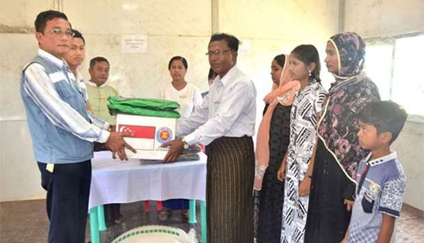 A Myanmar immigration official hands over identification document to a Rohingya family at Taungpyoletwei town repatriation camp in Maungdaw near Bangladesh border.