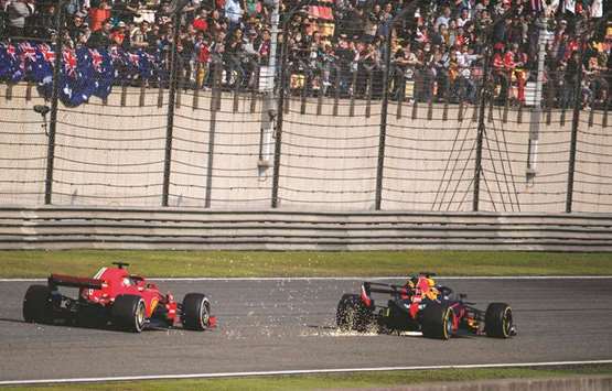 Sparks fly as Red Bullu2019s Daniel Ricciardo (right) overtakes Ferrariu2019s Sebastian Vettel during the Formula One Chinese Grand Prix in Shanghai yesterday. (AFP)