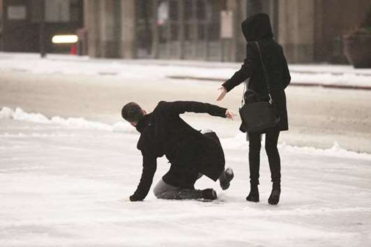 A man slips on ice covered sidewalk as freezing rain falls in Toronto.