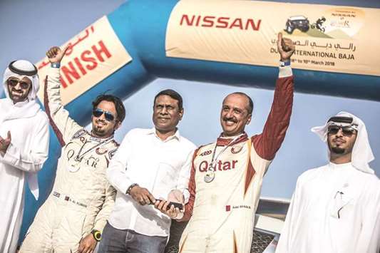 Qataru2019s Adel Abdulla (second from right) and co-driver Nasser al-Kuwari (second from left) on the podium at the Dubai International Baja in March.