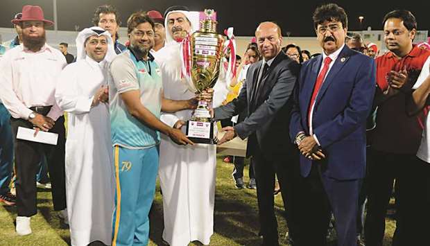 Qatar Cricket Association (QCA) president Yousef Jeham al-Kuwari and Qatar Airways Ticket Operations manager Ali Akbar Farabi present the Qatar Airways Premier Division Cricket Tournament winners trophy to Al Feroz Youngsters captain Inam-Ul Haq at the Asian Town Cricket Stadium in the presence of Eissa Yaqoob and other QCA officials.