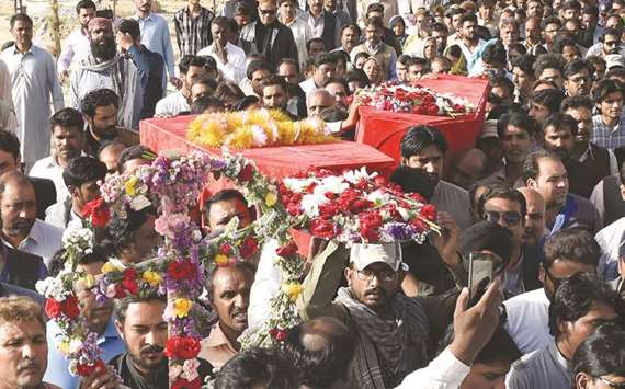 Mourners carry the coffins of community members who was killed on Sunday in Quetta, in a drive-by attack by gunmen.