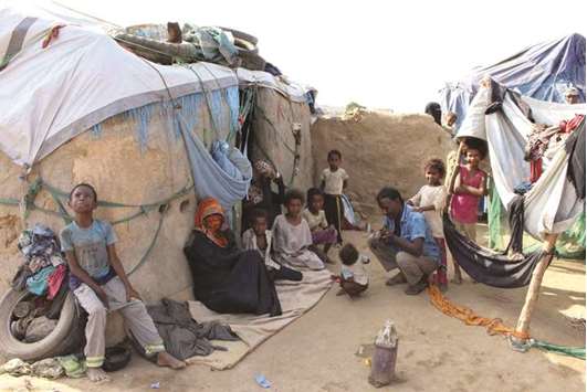 Displaced Yemenis sit outside their shelter at a make-shift camp for displaced people in the Haradh area, in the northern Abys district of Yemenu2019s Hajjah province.