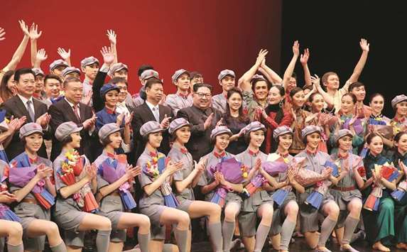 North Korean leader Kim Jong-un and his wife Ri Sol-ju posing with performers of the ballet choreodrama u201cRed Women Companyu201d of the Chinese art troupe and Song Tao, head of the International Liaison Department of the Central Committee of the Communist Party of China (middle 4th L), in Pyongyang.