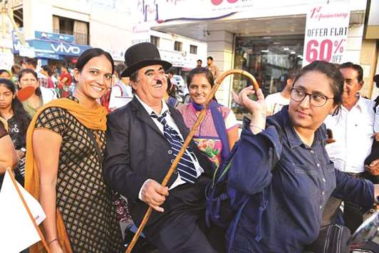 Ashok Aswani poses for photographs with bystanders in Adipur, some 60km northwest of Bhuj in Gujarat.