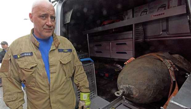 Demolition expert Roger Flakowski poses next to another defused World War II bomb on April 13, 2018 in Neu-Ulm, southern Germany, where around 12,000 residents had to be evacuated due to the disposal of the bomb.