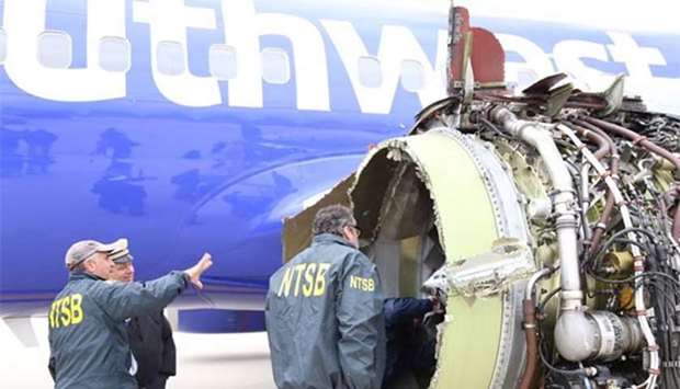 NTSB investigators examining damage to the engine of the Southwest Airlines plane.