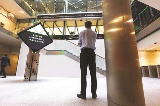A visitor looks at a ticker of share prices in the atrium of the London Stock Exchange Group offices in Paternoster Square. The FTSE 100 closed 1.3% up at 7,317.34 points yesterday.