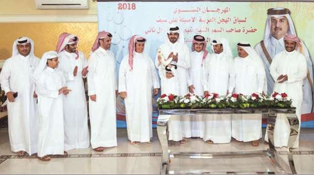 HE Sheikh Joaan bin Hamad al-Thani, president of the Qatar Olympic Committee (QOC), with the winners of the HH the Emir Cup at the Arabian Camel Festival.