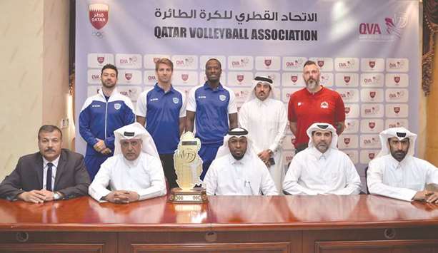 Qatar Volleyball Association officials, Al Rayyan Club and Police players and coaches pose with the Qatar Cup volleyball trophy yesterday.