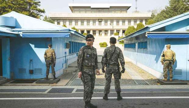 South Korean soldiers standing guard before a United Nations Command Military Armistice Commission (UNCMAC) meeting hut in the truce village of Panmunjom within the Demilitarised Zone (DMZ) separating North and South Korea.