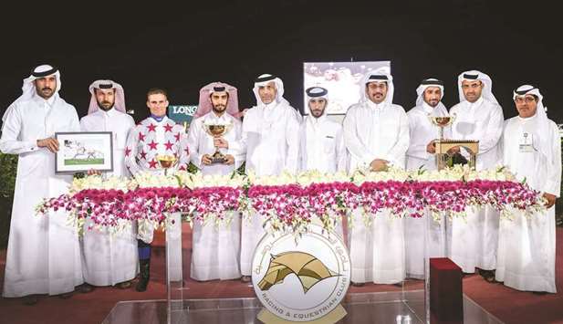 Qatar Racing and Equestrian Club (QREC) general manager Nasser Sherida al-Kaabi (fourth from right) and QREC deputy chief steward Abdulla Rashid al-Kubaisi (right) with the winners of the Qatari Breeders Trophy (The Late Rashid Mubarak Al Shafi) after AJS Jamra won the 1400m race at the QREC yesterday. PICTURES: Juhaim