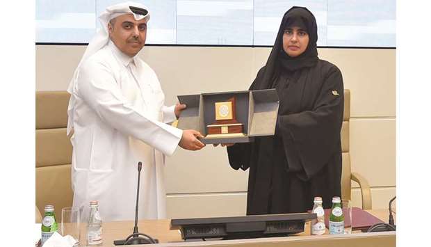 Rashid bin Mohamed al-Nuaimi receiving a commemorative plaque from Prof Mariam al-Maadeed.