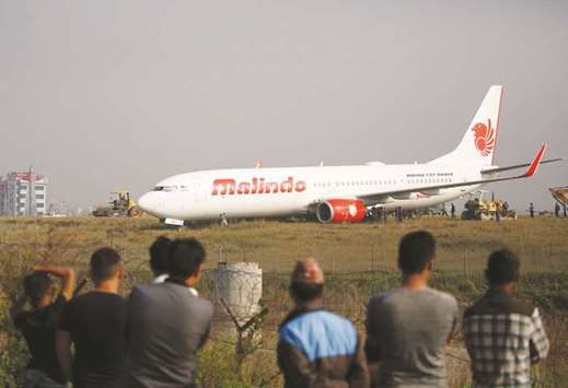 People look at an aircraft belonging to Malindo Air that skidded off the runway during takeoff on Thursday night at Tribhuvan International Airport in Kathmandu, yesterday.