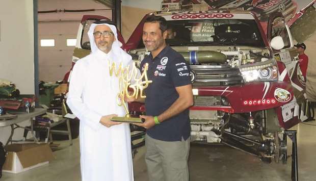 HE Salah bin Ghanem bin Nasser al-Ali, Minister for Culture and Sports, felicitates Qataru2019s ace driver Nasser Saleh al-Attiyah on the sidelines of the Manateq Qatar Cross-Country Rally at the Losail International Circuit yesterday.