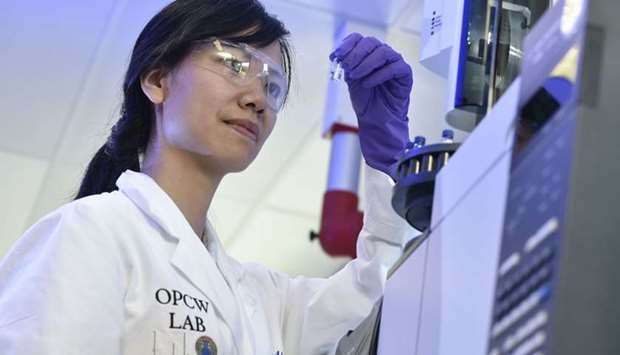 A laboratory technician controls a test vial at the OPCW (The Organisation for the Prohibition of Chemical Weapons) headquarters in the Hague, The Netherlands.