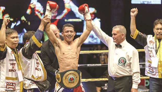 Filipino boxer Michael Dasmarinas (centre) celebrates after defeating French opponent Karim Guerfi during the International Boxing Organisation (IBO) batamweight world title in Singapore. (AFP)