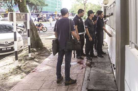 Malaysian forensic police collect evidence in the area where a Palestinian scientist was assassinated in Kuala Lumpur yesterday.