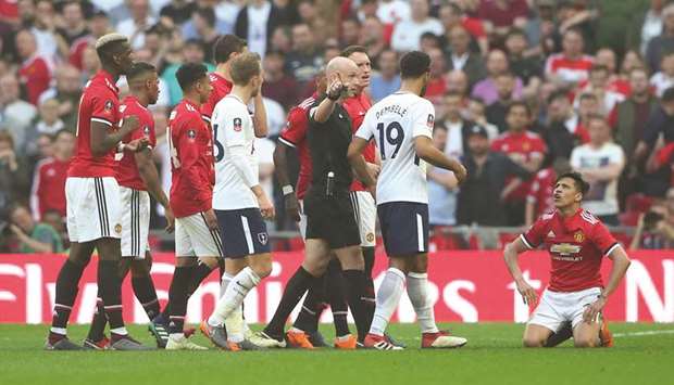 Referee Anthony Taylor gestures to Tottenhamu2019s Mousa Dembele as Manchester Unitedu2019s Alexis Sanchez (right) reacts angrily after being fouled during the FA Cup semi-final at the Wembley Stadium in London yesterday. United won 2-1. (Reuters)