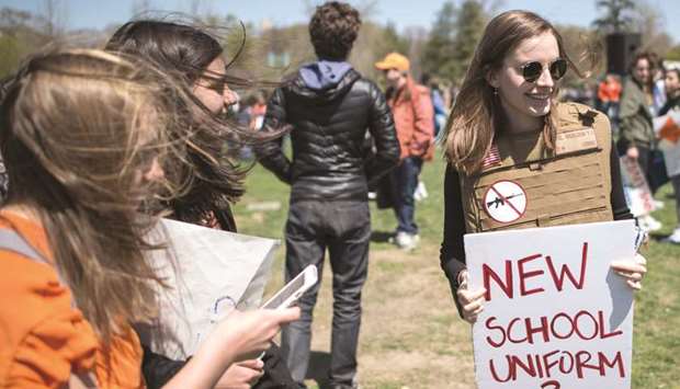 Yorktown High School junior Zoe Coutlakis holds a sign on the West Lawn of the US Capitol after rallying on Friday with several hundred fellow students to call for stricter gun laws.