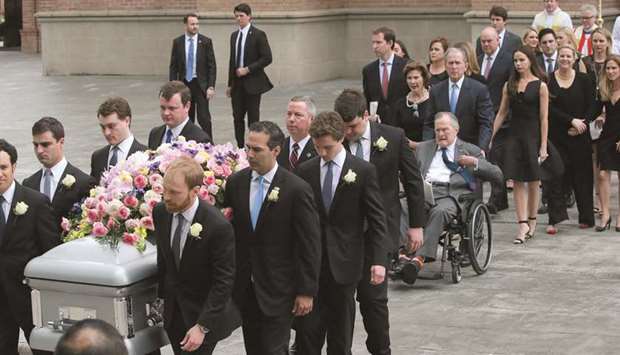 Former US president George H W Bush, in a wheelchair, is pushed by former president George W Bush, behind the coffin of his wife, former first lady Barbara Bush.